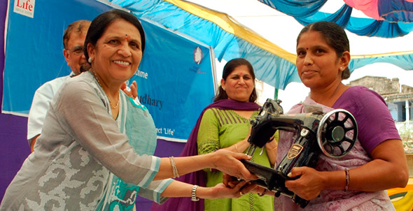 Woman accepting her sewing machine after completion of 12 weeks vocational training.
